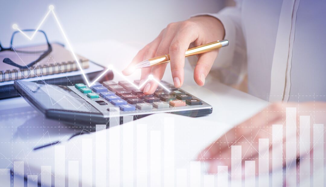 Mãos usando calculadora com gráfico ao fundo