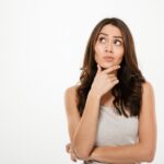 Mulher pensativa com expressão curiosa.