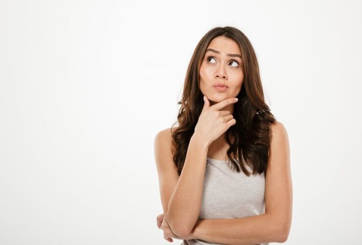 Mulher pensativa com expressão curiosa.