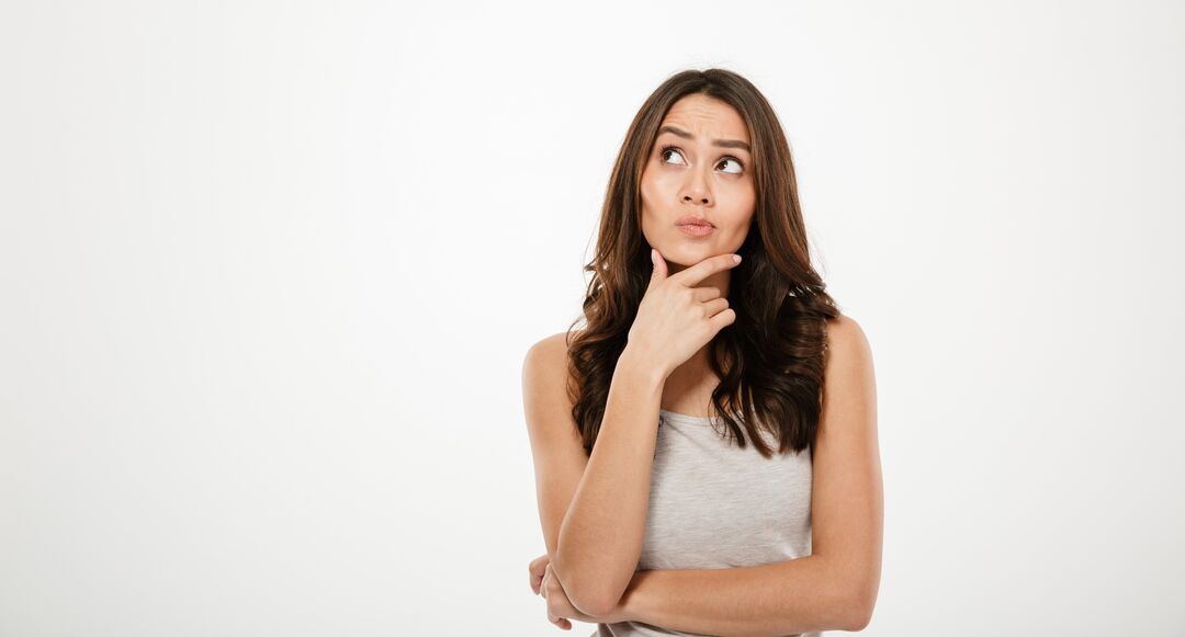 Mulher pensativa com expressão curiosa.